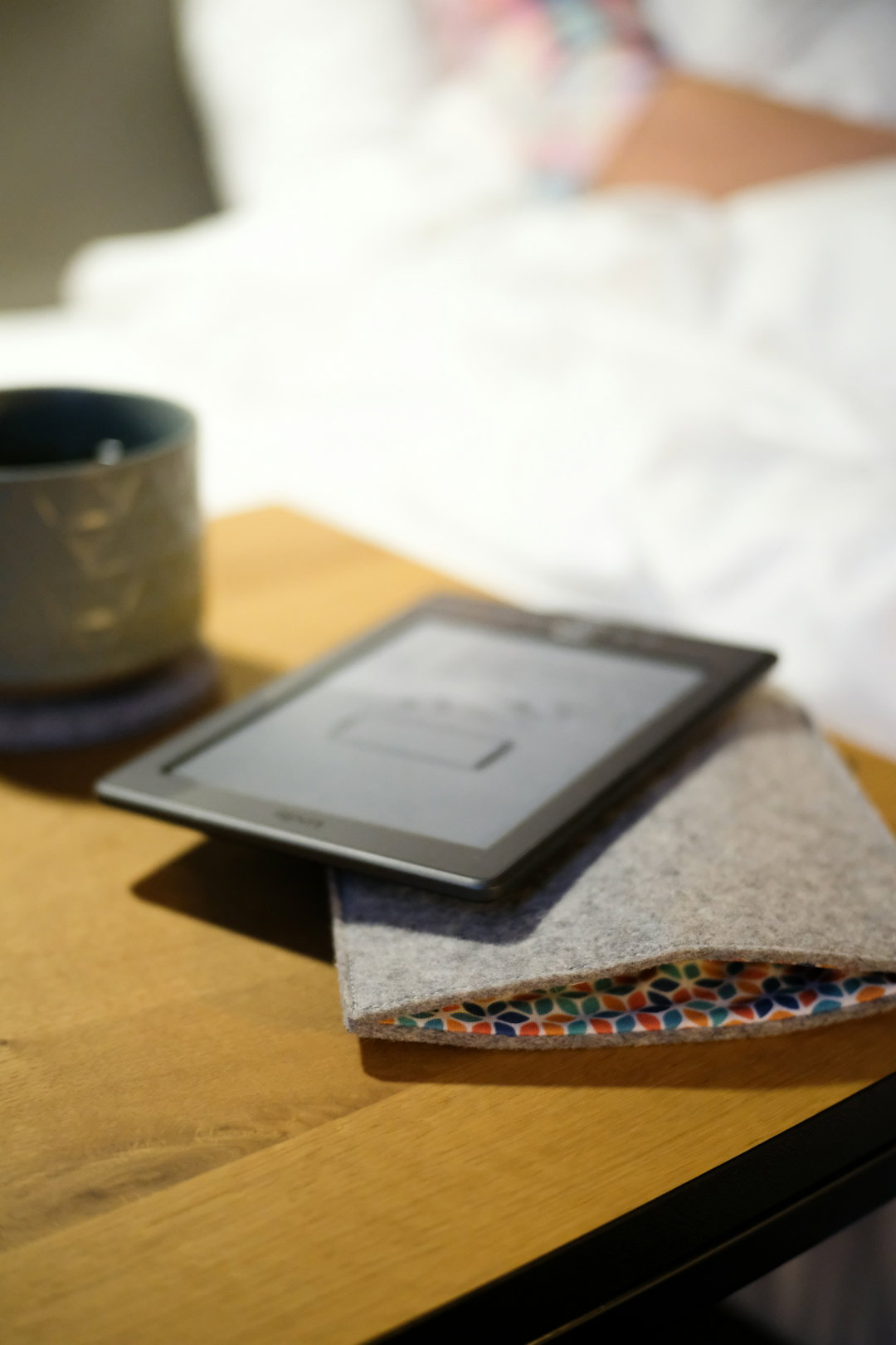A table with a tablet and a cup on it